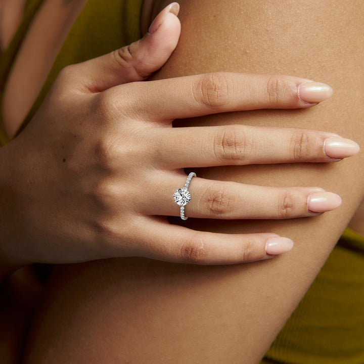 White gold round brilliant-cut compass pave hidden halo engagement ring, worn on the hand