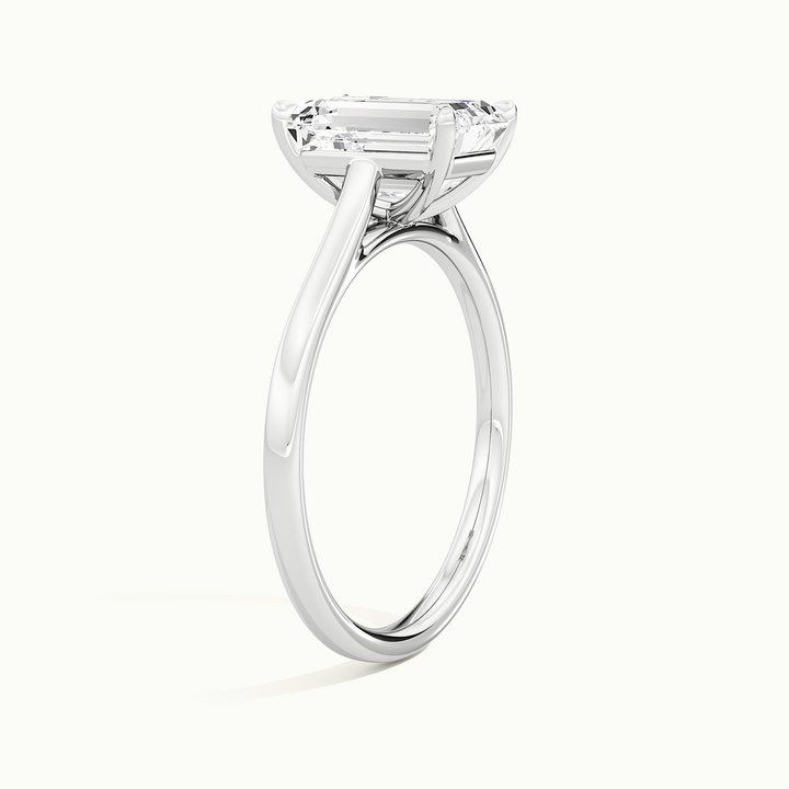 White gold emerald-cut cathedral solitaire engagement ring, raised three-quarter view of the setting