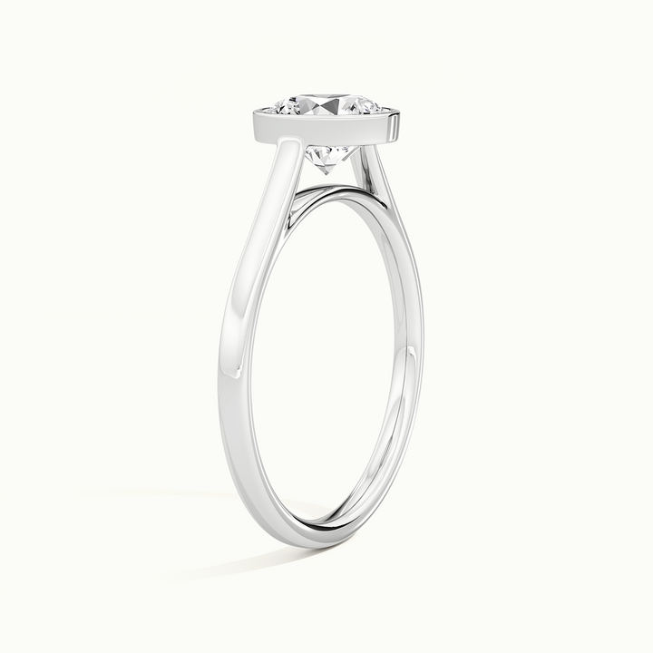 White gold round brilliant-cut bezel-set solitaire engagement ring, raised three-quarter view of the setting
