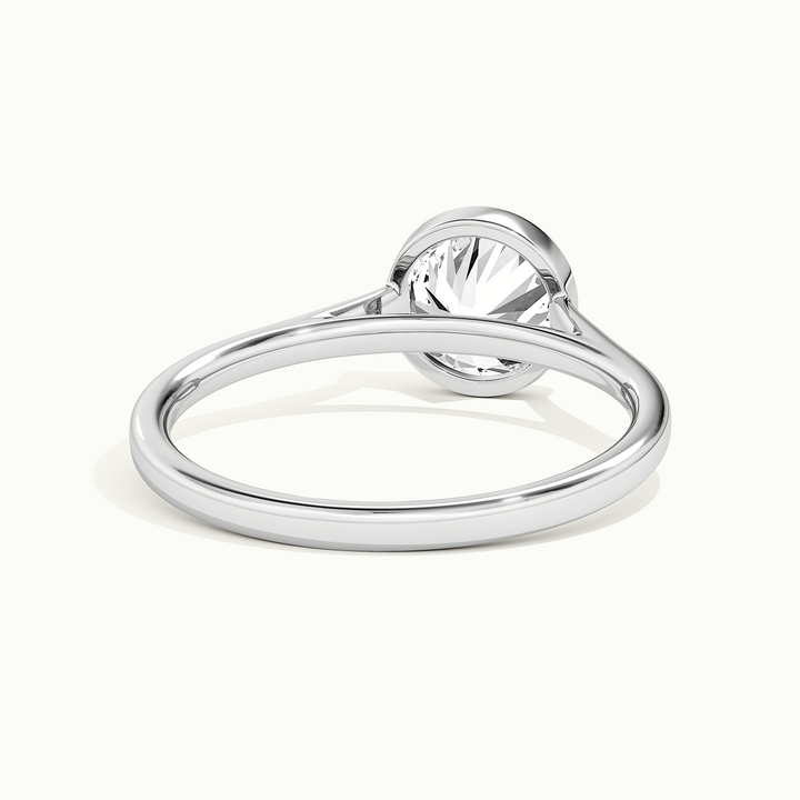 White gold round brilliant-cut bezel-set solitaire engagement ring, rear view showing the setting gallery