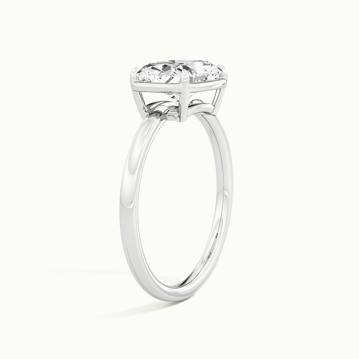 White gold elongated cushion-cut east-west bezel-frame solitaire engagement ring, raised three-quarter view of the setting