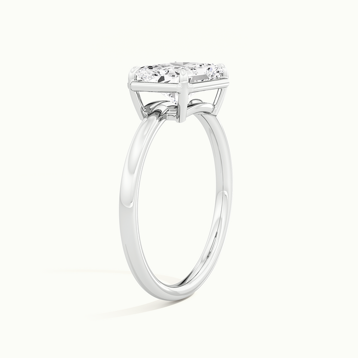 White gold radiant-cut east-west bezel-frame solitaire engagement ring, raised three-quarter view of the setting