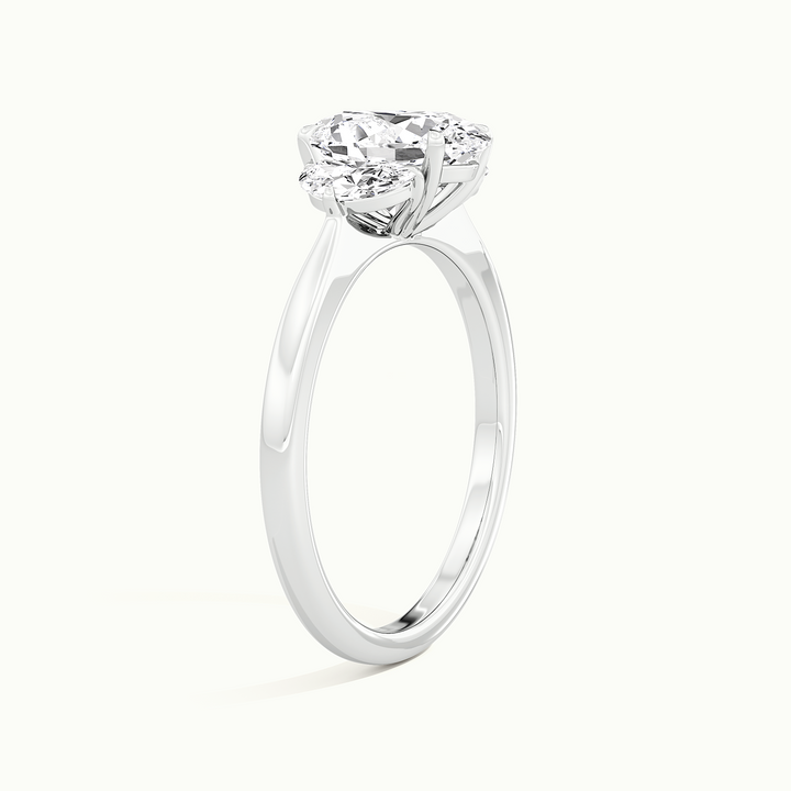 White gold oval-cut three-stone with half-moon side stones, raised three-quarter view of the setting