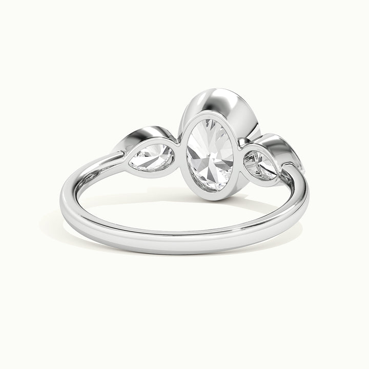 White gold oval-cut bezel-set three-stone with pear side stones engagement ring, rear view showing the setting gallery