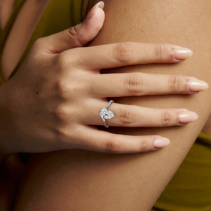 White gold pear-cut V band solitaire engagement ring, worn on the hand